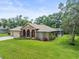 Charming single-story home with well-manicured lawn, screened in pool, and mature trees at 2409 Heather Manor Ln, Lutz, FL 33549