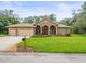 Beautiful home featuring a well-manicured lawn, three-car garage, and arched entryway, providing curb appeal at 2409 Heather Manor Ln, Lutz, FL 33549