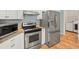 Modern kitchen featuring stainless steel appliances, granite countertops, and white cabinets at 2409 Heather Manor Ln, Lutz, FL 33549