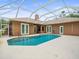 Inviting screened-in pool area with clear blue water, surrounded by a spacious deck and backyard at 2409 Heather Manor Ln, Lutz, FL 33549
