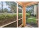 Screened patio surrounded by lush green plants and view to back yard at 2570 Sea Wind Way, Clearwater, FL 33763