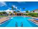 Community pool with a shaded cabana and lounge chairs on a sunny day at 2570 Sea Wind Way, Clearwater, FL 33763