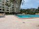 Inviting outdoor pool area with comfortable lounge chairs, clear blue water, and lush landscaping at 2621 Cove Cay Dr # 206, Clearwater, FL 33760