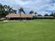 Lush green putting course with flag markers and a covered clubhouse in the background at 2621 Cove Cay Dr # 206, Clearwater, FL 33760