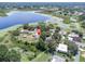 An aerial view of the home featuring a private pool near a lake with lush green trees at 271 Eastpoint Ct, Spring Hill, FL 34606
