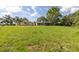Wide grassy backyard area with mature trees and landscaping around the property at 271 Eastpoint Ct, Spring Hill, FL 34606