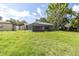 Spacious backyard with a screened lanai, mature trees, and well-maintained lawn at 271 Eastpoint Ct, Spring Hill, FL 34606