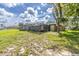 Spacious backyard with a screened lanai, mature trees, and well-maintained lawn at 271 Eastpoint Ct, Spring Hill, FL 34606