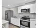 This kitchen is equipped with stainless steel appliances and modern white cabinets at 271 Eastpoint Ct, Spring Hill, FL 34606