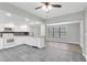 Modern kitchen features white cabinets, appliances, gray countertops and opens to living room at 271 Eastpoint Ct, Spring Hill, FL 34606