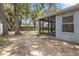 Exterior shot of the screened-in lanai, offering tranquil views of the lush green backyard and mature trees at 2910 Red Coat Cir, Brandon, FL 33511