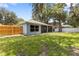 Landscaped backyard featuring a screened patio, lush lawn and established privacy fence at 2910 Red Coat Cir, Brandon, FL 33511