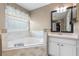 Bright bathroom featuring a soaking tub, window, and vanity with sink at 2910 Red Coat Cir, Brandon, FL 33511
