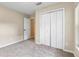 Neutral bedroom featuring carpet flooring, white closet doors, and a side door at 2910 Red Coat Cir, Brandon, FL 33511