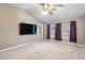 Bright bedroom with vaulted ceiling, ceiling fan, neutral carpeting, and a door leading to the backyard at 2910 Red Coat Cir, Brandon, FL 33511