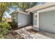 Inviting entrance with a gray walkway, matching garage door, and manicured landscaping at 2910 Red Coat Cir, Brandon, FL 33511
