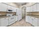 Kitchen with white appliances, cabinets and wood-look floors at 2910 Red Coat Cir, Brandon, FL 33511