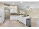 Open concept kitchen with white cabinetry, adjacent to living area with wood-look floors at 2910 Red Coat Cir, Brandon, FL 33511