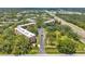 Aerial view of condo community showcasing buildings, manicured lawns, a line of palm trees, and lush greenery at 3062 Eastland Blvd # 311, Clearwater, FL 33761