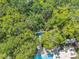 Aerial view of a pool and lounge area surrounded by lush greenery and shady trees at 3062 Eastland Blvd # 311, Clearwater, FL 33761