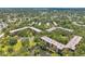 Aerial view of condo buildings surrounded by lush trees, green space, and a serene pond at 3062 Eastland Blvd # 311, Clearwater, FL 33761