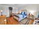 Bright bedroom featuring wood floors, brass bed frame, with mounted TV, and light colored walls at 3062 Eastland Blvd # 311, Clearwater, FL 33761