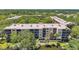 Condominium building with water view, neutral color, and multiple stories surrounded by mature trees at 3062 Eastland Blvd # 311, Clearwater, FL 33761