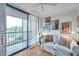 Bright living room features a comfortable couch, bright posters and an open sliding door leading to the patio at 3062 Eastland Blvd # 311, Clearwater, FL 33761
