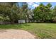 Lush backyard featuring green space, mature trees, and storage shed at 4321 S Thatcher Ave, Tampa, FL 33611