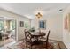 Dining room features a round wood table, classic chairs, decorative art, and a sliding door to a sunroom at 4321 S Thatcher Ave, Tampa, FL 33611