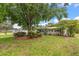 Charming home featuring a well-manicured lawn, a driveway, an attached garage, and lovely landscaping at 4321 S Thatcher Ave, Tampa, FL 33611