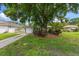 Charming home featuring a well-manicured lawn, a driveway, an attached garage, and lovely landscaping at 4321 S Thatcher Ave, Tampa, FL 33611