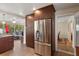 Open-concept kitchen with stainless steel refrigerator, wood cabinets, and view to the bright, airy sunroom at 4321 S Thatcher Ave, Tampa, FL 33611