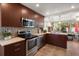 Stylish kitchen boasts stainless steel appliances, rich cabinetry, mosaic backsplash, and sunroom access at 4321 S Thatcher Ave, Tampa, FL 33611