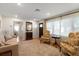 Cozy living room features a patterned rug, neutral sofa, and floral armchairs with light-filled windows at 4321 S Thatcher Ave, Tampa, FL 33611