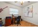 Home office with hardwood floors, desk, office chair, and natural light from a window with blinds at 4321 S Thatcher Ave, Tampa, FL 33611
