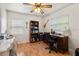 Functional home office with hardwood floors, dual desks, a bookcase, and natural light from two windows at 4321 S Thatcher Ave, Tampa, FL 33611