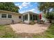 An outdoor patio with brick pavers extends from a sunroom with a table, chairs, and a red umbrella at 4321 S Thatcher Ave, Tampa, FL 33611