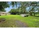 Spacious backyard featuring lush greenery, mature trees, and additional structures for storage or hobbies at 4708 Bugg Rd, Plant City, FL 33567