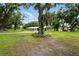 Lush backyard featuring large trees, a house, and covered parking at 4708 Bugg Rd, Plant City, FL 33567