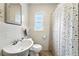 Bathroom featuring a pedestal sink, toilet, window and shower with patterned curtain at 4708 Bugg Rd, Plant City, FL 33567