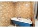 Clawfoot tub featuring tiled walls, a towel, and toiletries at 4708 Bugg Rd, Plant City, FL 33567