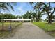 Gravel driveway leading to a house with covered parking and a green lawn at 4708 Bugg Rd, Plant City, FL 33567