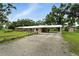 View of house exterior, gravel driveway, covered parking and well maintained lawn at 4708 Bugg Rd, Plant City, FL 33567