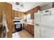 Kitchen featuring wood cabinets, an oven, and a refrigerator at 4708 Bugg Rd, Plant City, FL 33567