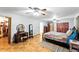 Spacious main bedroom featuring parquet floors, ceiling fan, dressing table, and convenient walk-in closet at 4708 Bugg Rd, Plant City, FL 33567