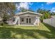 Covered back patio with ceiling fan, providing a comfortable outdoor living space with access through double doors at 4717 W Anita Blvd, Tampa, FL 33611