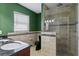 Bathroom featuring a toilet, large glass shower, and vanity with granite countertop and decorative tile accents at 4717 W Anita Blvd, Tampa, FL 33611