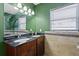 Bathroom featuring dual sinks, granite countertop, dark wood cabinets, and decorative tile accents at 4717 W Anita Blvd, Tampa, FL 33611