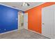 Bedroom with blue and orange walls, showing entry doorway and closet with bi-fold doors at 4717 W Anita Blvd, Tampa, FL 33611